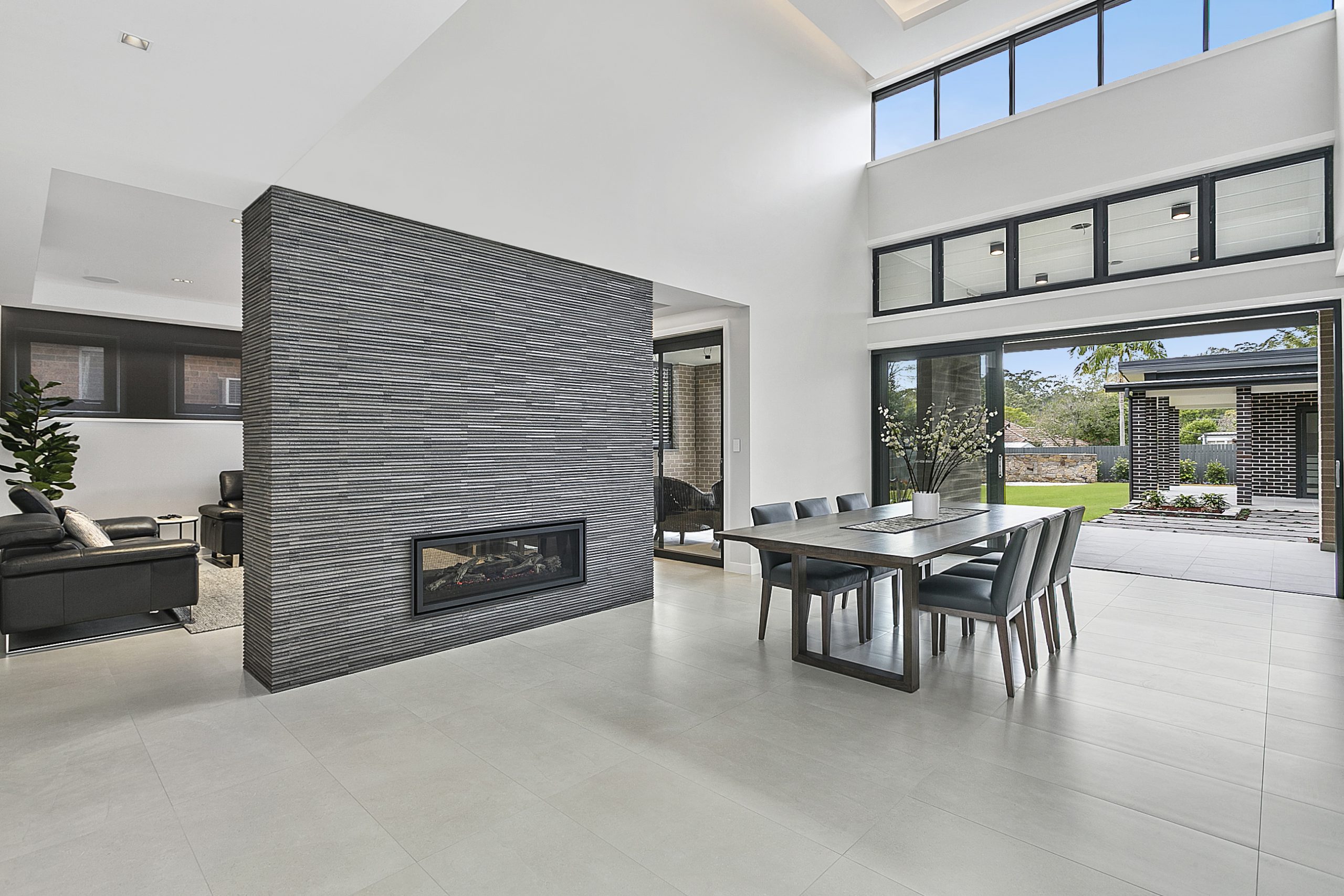sleek dining room with outdoor access and stone fireplace