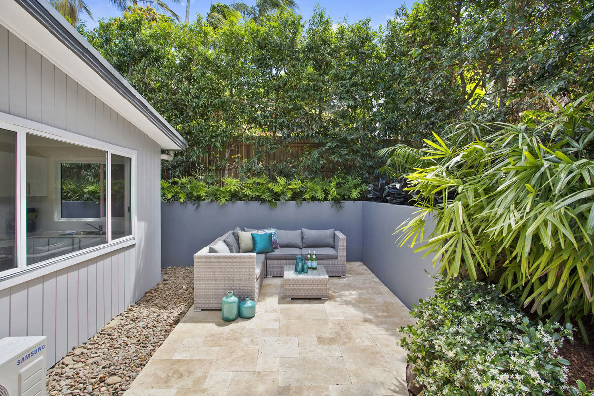 Small outdoor patio with lounge and privacy walls