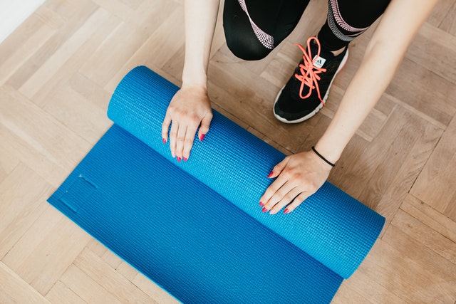 rolling up a yoga mat in home gym space